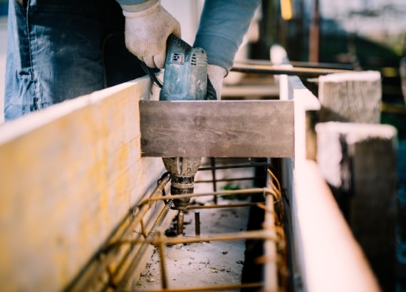 man drilling into foundation work