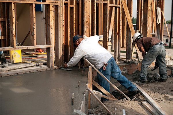 two men working hard to lay a foundation